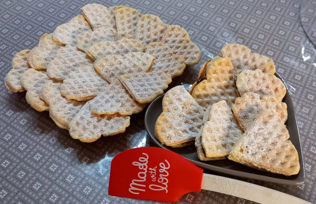 Cuore di cialde morbide spolverate di zucchero a velo, pronte per essere gustate.