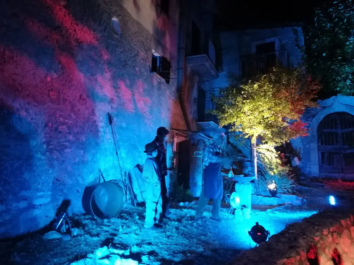 Scenografia suggestiva per la festa delle streghe in Abruzzo. Figure misteriose e luci colorate creano un'atmosfera magica.