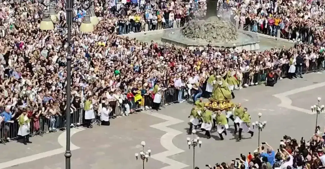 Processione con la statua della Madonna che scappa, portata a spalla da uomini in costume, tra una folla di fedeli festanti.