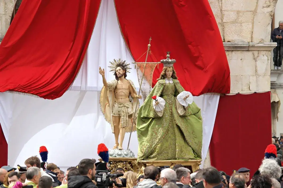 Statue di Ges&ugrave; e della Madonna che scappa a Sulmona, con drappi rossi e bianchi e folla in attesa.