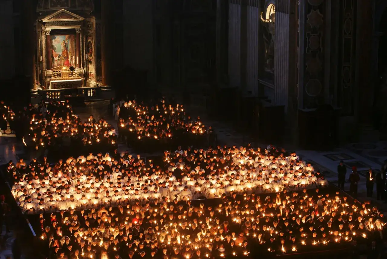 Una folla immensa, illuminata da centinaia di candele, celebra il giorno della Candelora in una chiesa maestosa.