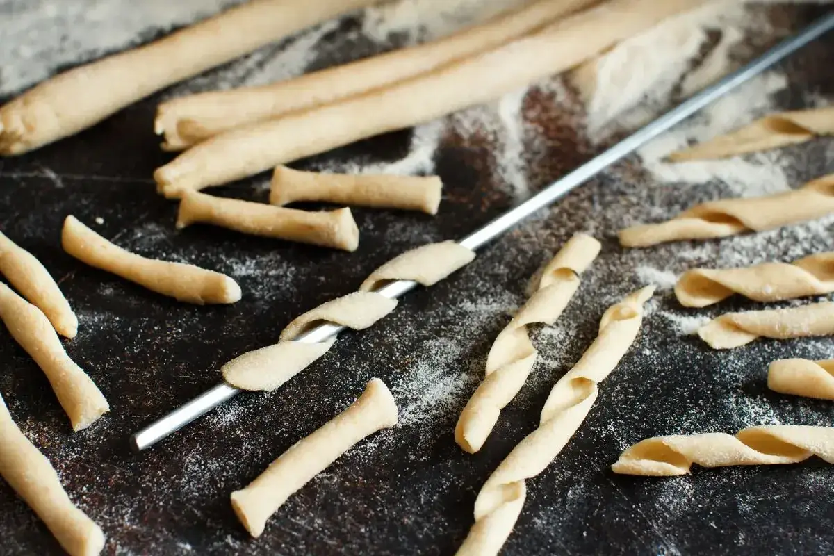 Maccheroni alla chitarra molisani in preparazione, con la pasta che viene attorcigliata su un ferro.
