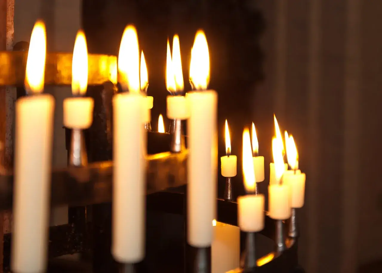 Fiamme danzanti di candele accese, un'atmosfera suggestiva che ricorda la festa della Candelora e il suo proverbio.