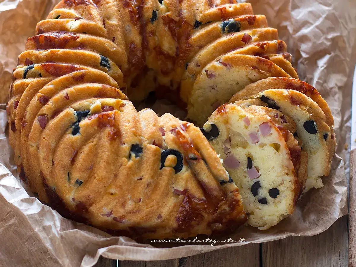 Una gustosa ciambella salata napoletana, ricca di olive nere e cubetti di prosciutto, pronta per essere gustata.