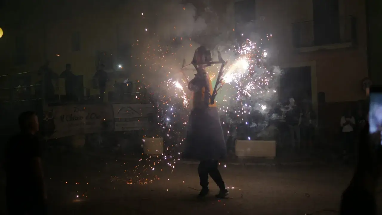 Il Palio delle Pupe a Cappelle sul Tavo: un figurante con fuochi d'artificio illumina la notte.