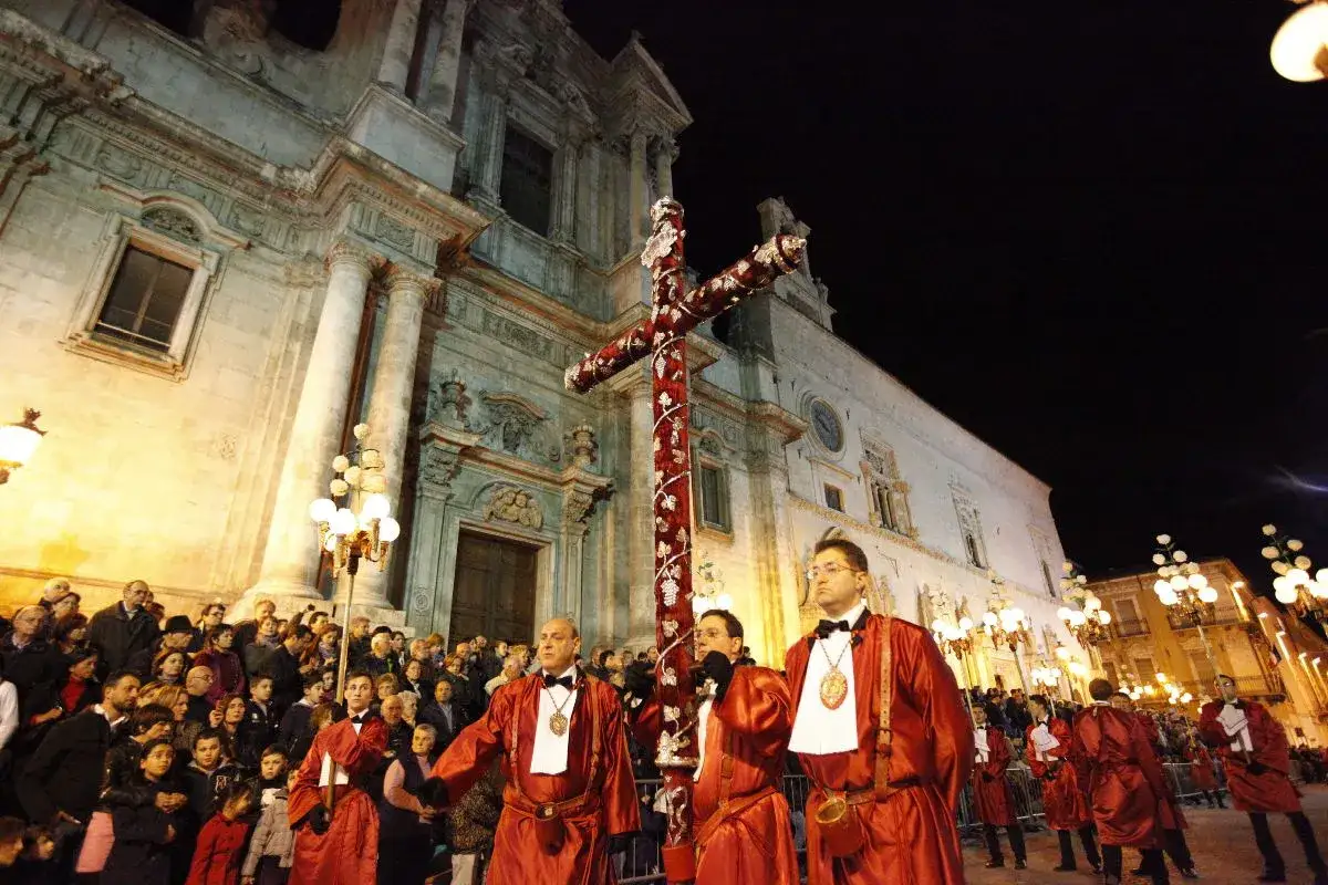 La processione del Venerdì Santo a Sulmona sfila con la croce decorata davanti a una folla.