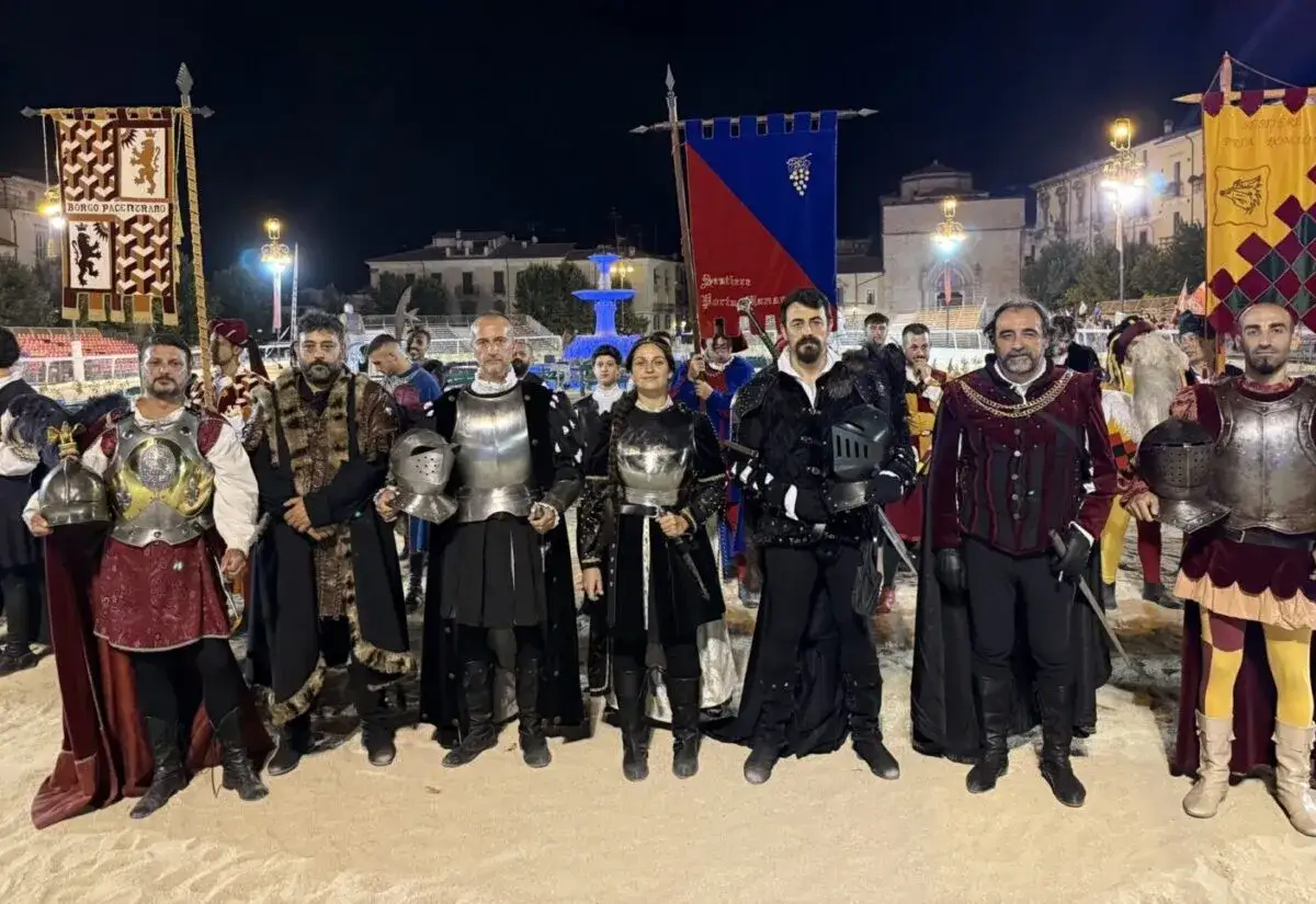 Partecipanti alla giostra cavalleresca di Sulmona in costume storico, con armature e stendardi.