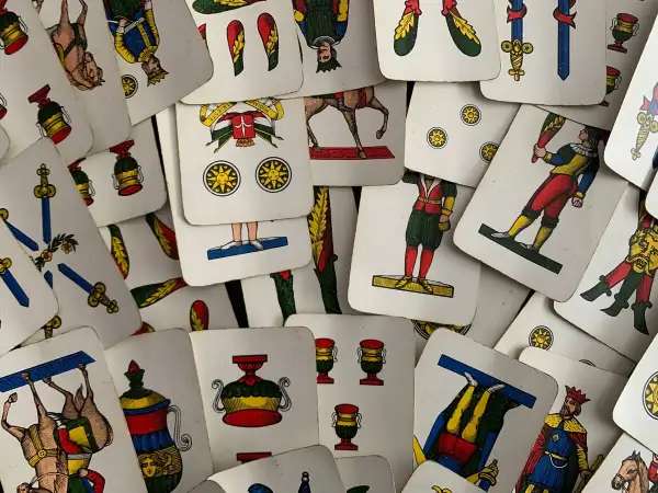 Un mazzo di carte napoletane, con l'asso di bastoni in primo piano, pronto per una partita.