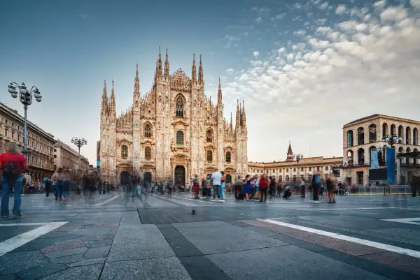 Piazza del Duomo a Milano, con la cattedrale imponente e gente che passeggia. Un luogo dove si respira la storia e i proverbi milanesi.