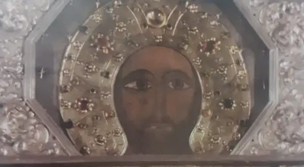 Volto del Cristo Acheropita, icona bizantina con aureola decorata da gemme e ricami dorati, incastonata in una cornice argentata.