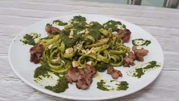 Pasta fresca con crema di friarielli e pezzetti di salsiccia croccante. Un piatto gustoso e colorato.