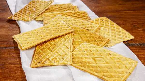 Un mucchio di ferratelle dolci, croccanti e dorate, pronte per essere gustate su un tovagliolo bianco.