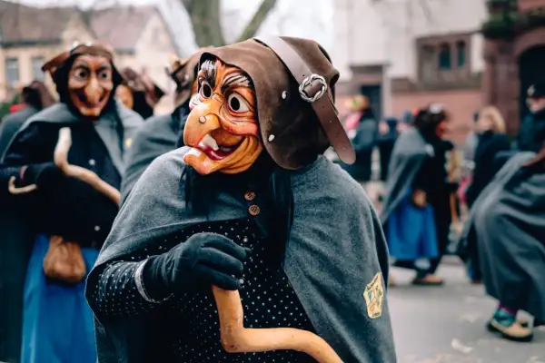 Maschere spaventose e costumi tradizionali in una sfilata, forse quando è Epifania.