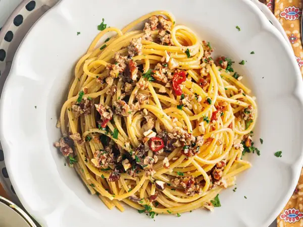 Spaghetti con le noci, un sapore autentico della ricetta napoletana, conditi con noci tritate, peperoncino e prezzemolo fresco.